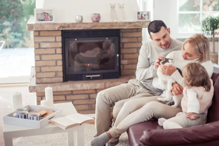 The family sits on the couch near the fireplace